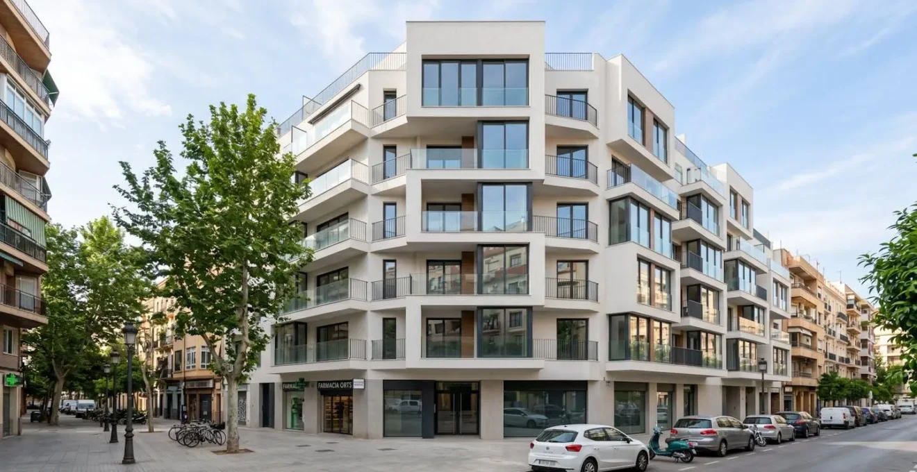 Fachada de un edificio residencial contemporáneo con ventanas amplias y balcones limpios, en un día soleado, sin personas en primer plano